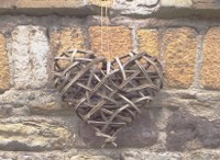 Aus Weiden geflochtenes Herz am Haus in FR